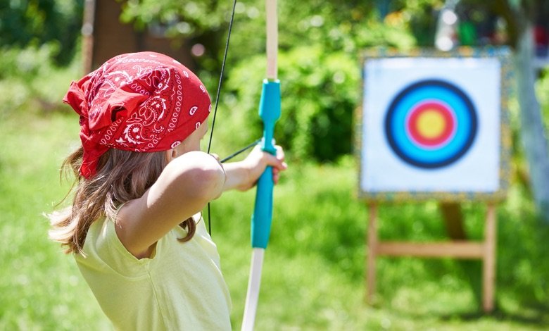 Girl with bow shooting to sport aim